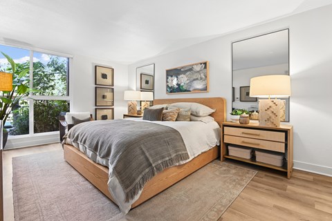 A bedroom with a large bed, a dresser, and a mirror.