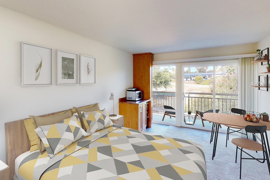 A bedroom with a bed, a table, chairs, and pictures on the wall at West Park Village, Los Angeles, CA