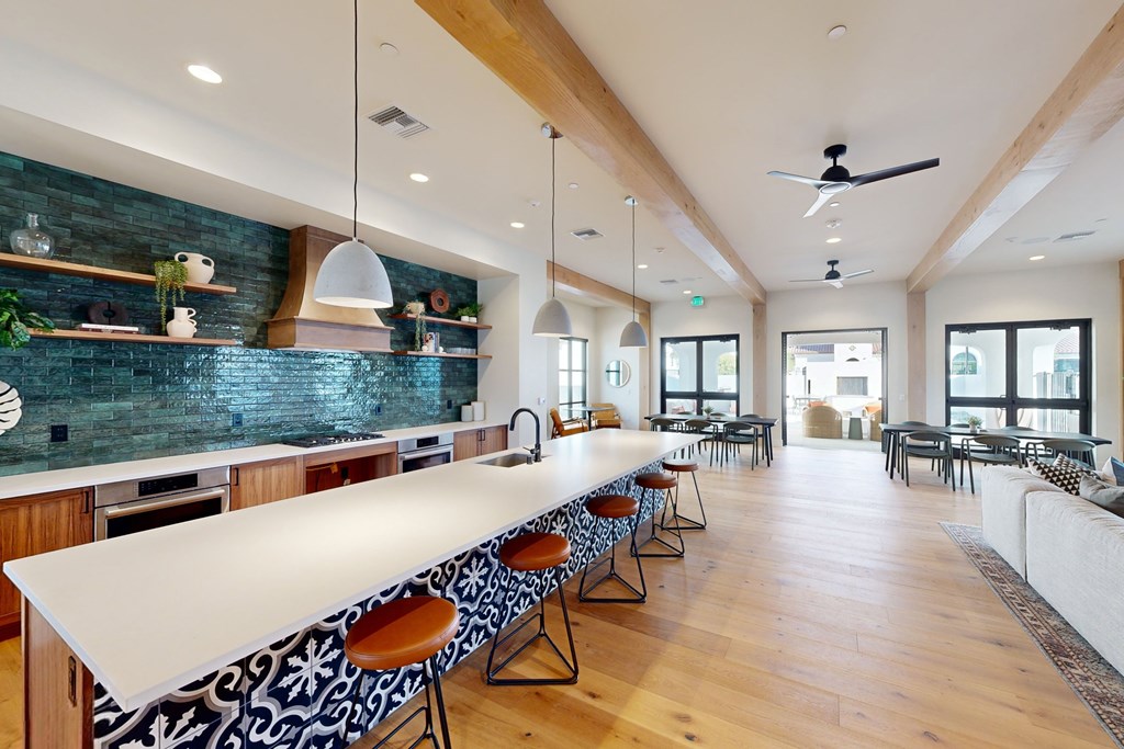 A long white table with chairs is in the middle of a room with a ceiling fan at The Villas at Anacapa Canyon, Camarillo, 93012