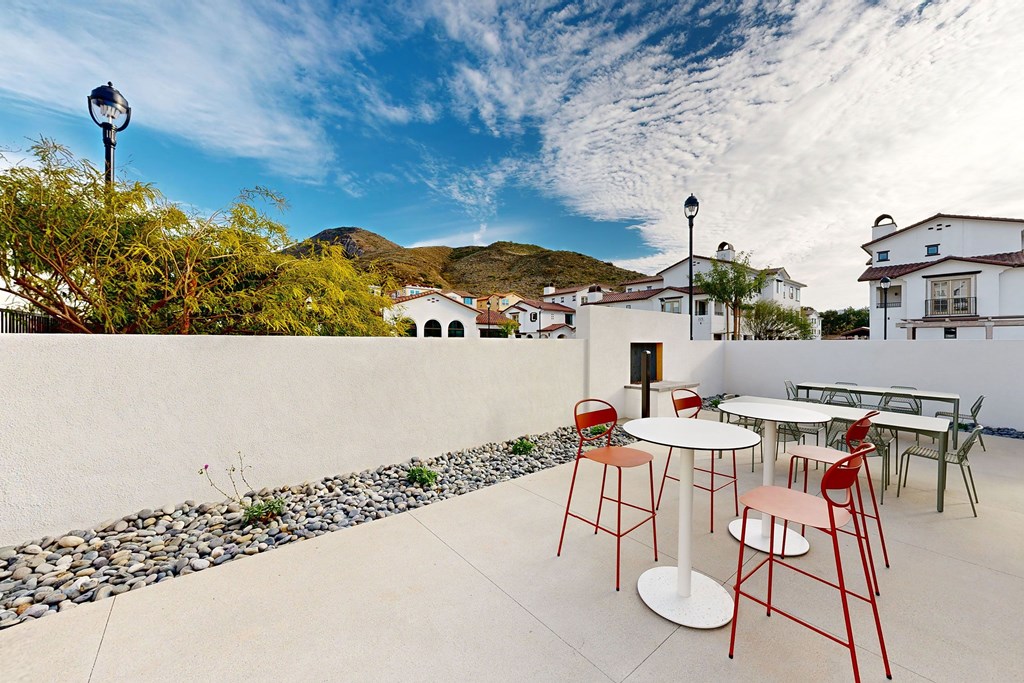 A patio with a table and chairs is set up on a sunny day at The Villas at Anacapa Canyon, Camarillo, 93012