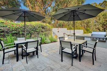 A patio with a table and chairs under umbrellas at Casa Granada, California, 90049