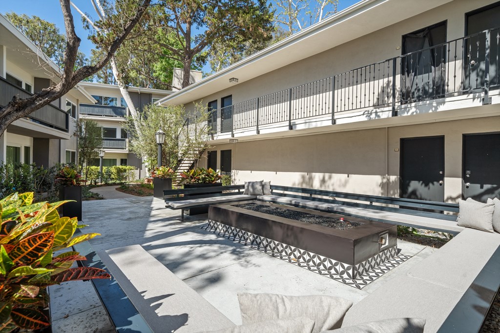 A patio with a table and chairs is surrounded by buildings at Villa Vicente, Los Angeles, CA