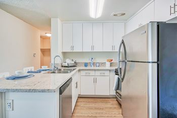 a kitchen with white cabinets and a stainless steel refrigerator at Villa Vicente, Los Angeles, CA, 90019