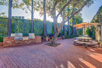 a brick patio with tables and umbrellas and trees at Villa Vicente, California