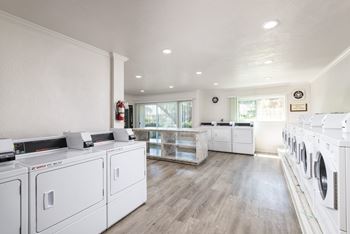 a washer and dryer room in a laundry room with white washes and