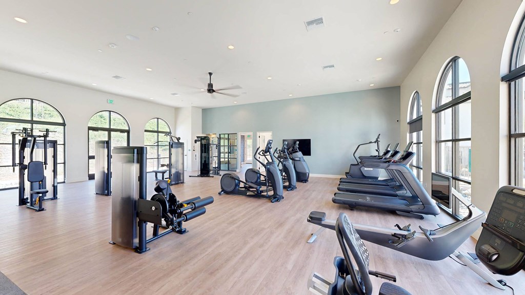a gym with cardio machines and weights on a wooden floor at The Villas at Anacapa Canyon, Camarillo, 93012