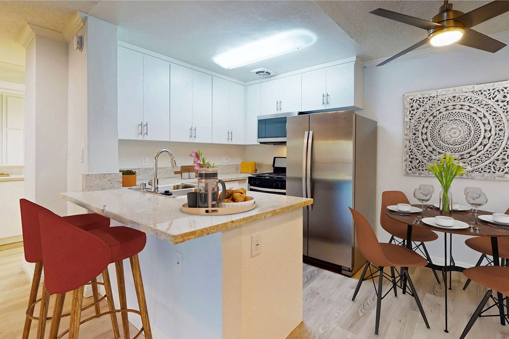 a kitchen with a breakfast bar and a stainless steel refrigerator a kitchen with a breakfast bar and a stainless steel refrigerator at Casa Granada, Los Angeles, 90049