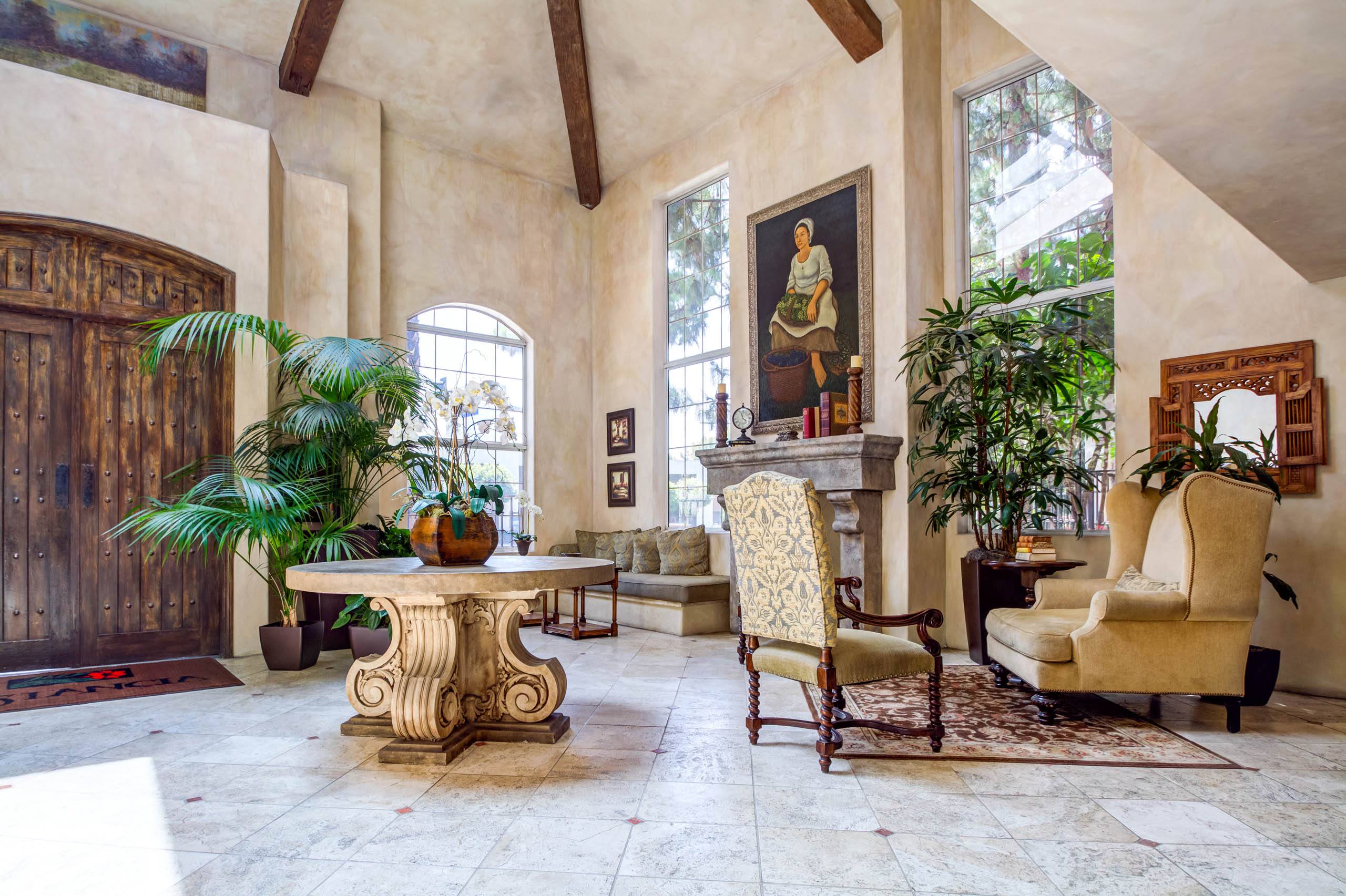 A living room with a large painting on the wall and a wooden door on the left.
