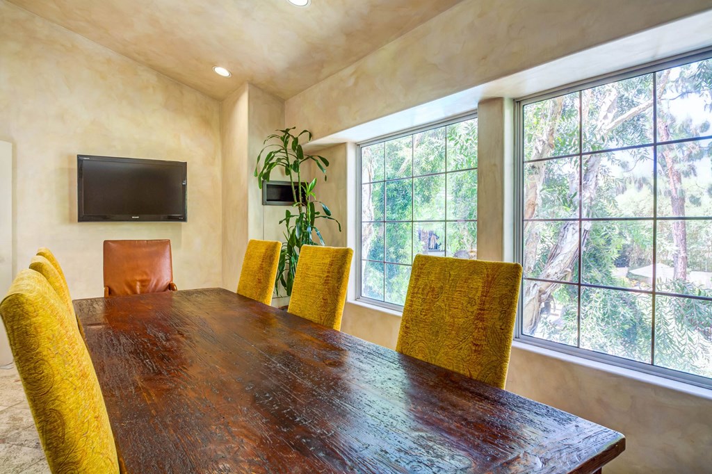 a dining room with a large window and a wooden table at L'Estancia, Studio City, 91604