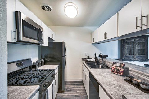 a kitchen with a stove and a sink and a refrigerator at Mediterranean Village Costa Mesa, Costa Mesa, CA