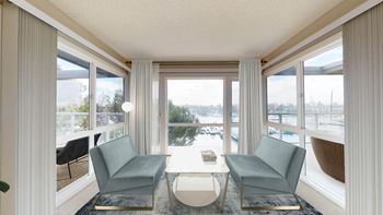 a living room with two blue chairs and a table and a view of the water  at Marina Harbor, Marina del Rey