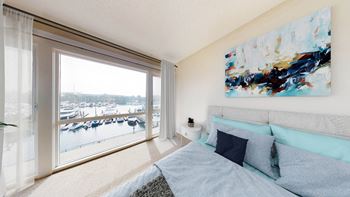 a bedroom with a large window and a bed with blue pillows  at Marina Harbor, California