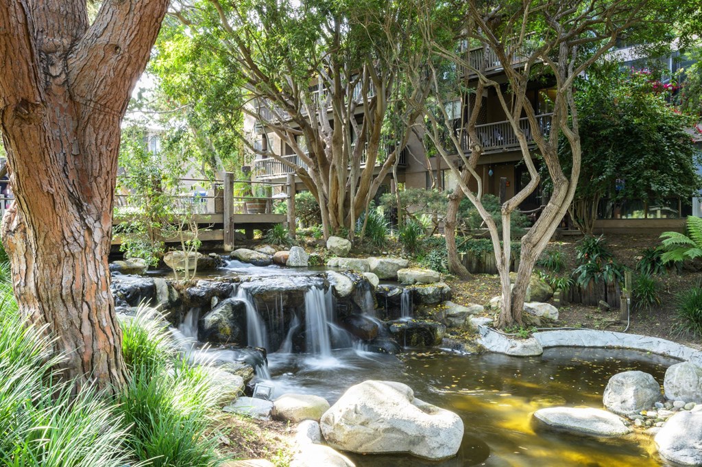 a garden with a waterfall and a house in the background at Mariners Village, Marina del Rey, 90292