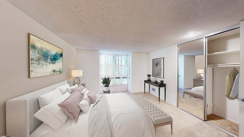 a bedroom with a large white bed and a mirror a bedroom with a large white bed and a mirror at Mariners Village, Marina del Rey