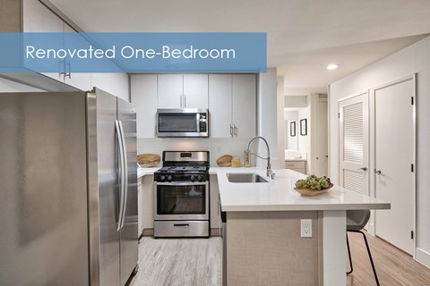 an updated one bedroom kitchen with stainless steel appliances and white cabinets at The Meadows Apartments, Culver City , CA