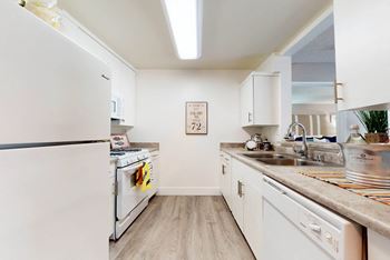 a kitchen with white appliances and white cabinets at Mountain Vista, Victorville, CA