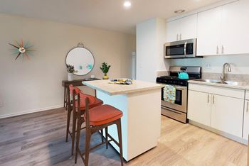a kitchen with an island and a counter top with three chairs  at Rancho Los Feliz, Los Angeles, CA, 90039