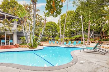 a swimming pool with blue chairs and a building in the background  at Rancho Los Feliz, Los Angeles, 90039