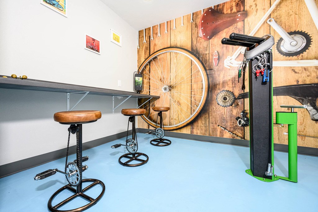 a bike room with stools and a bike wheel on a wall