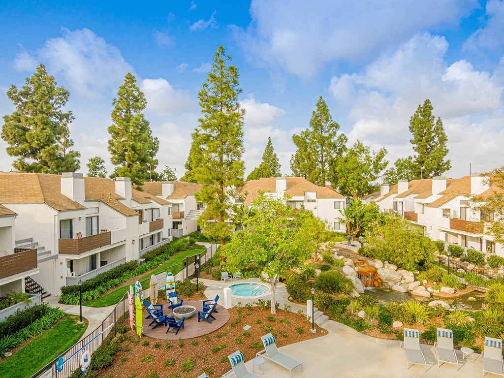 an aerial view of an apartment community with a pool and trees