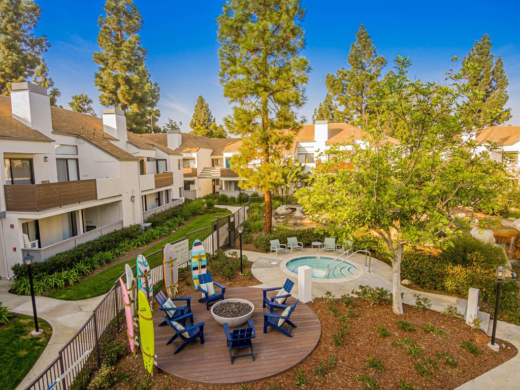 a courtyard with a pool and patio with chairs and trees
