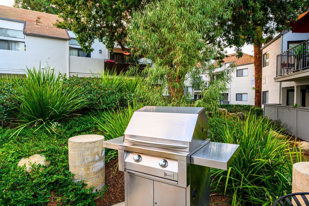 a stainless steel barbecue grill in the backyard of a house