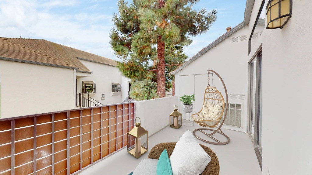 a patio with a swing and a chair on a balcony