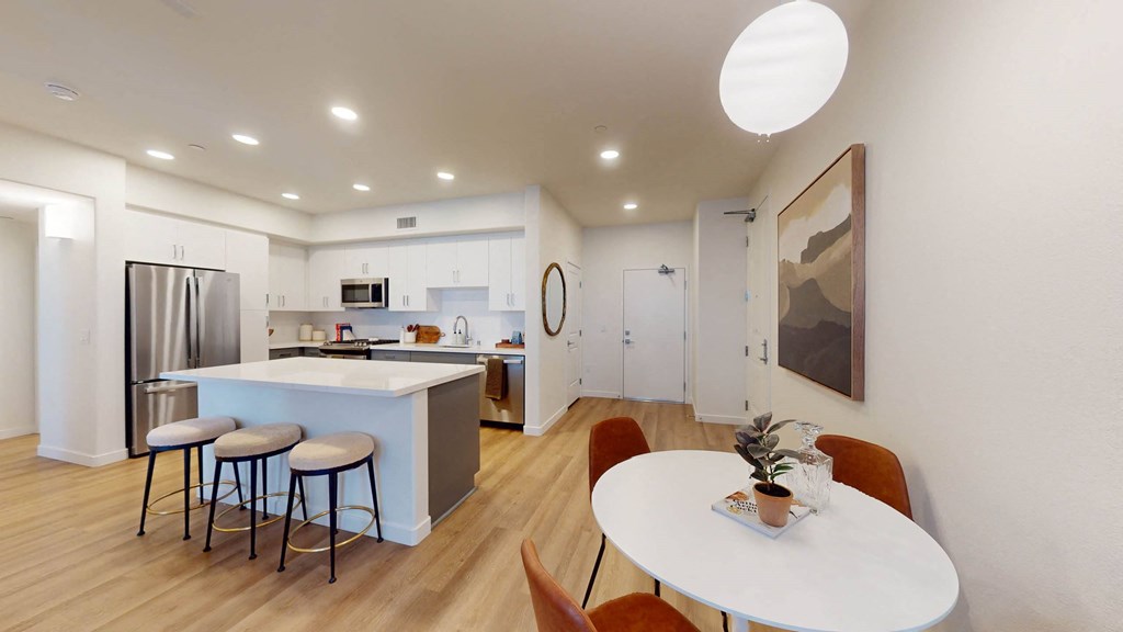 a kitchen and dining area with a table and stools at The Villas at Anacapa Canyon, Camarillo