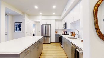 a large kitchen with stainless steel appliances and white counter tops at The Villas at Anacapa Canyon, Camarillo, CA