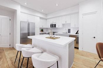 a white kitchen with three stools in front of a counter at The Villas at Anacapa Canyon, Camarillo