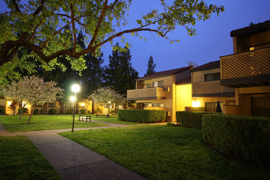 the apartments are lit up at night and the courtyard is empty at Valley Plaza Villages, California, 94566