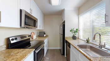 a kitchen with stainless steel appliances and granite counter tops at Valley Plaza Villages, California