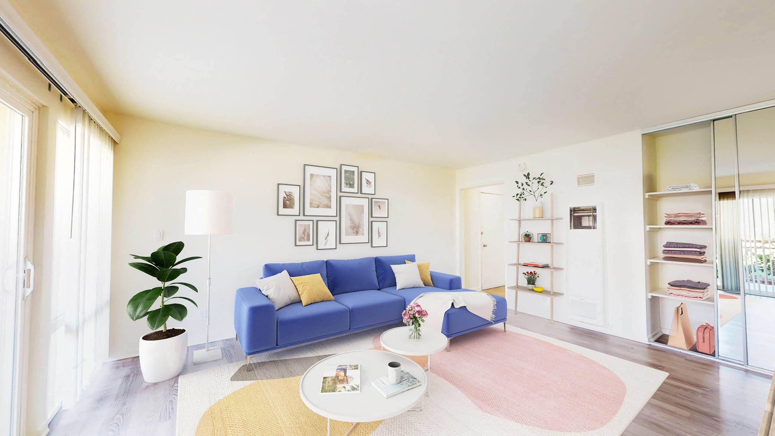 a living room with a blue couch and a pink rug