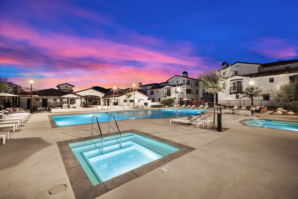 a swimming pool at dusk with apartments in the background at The Villas at Anacapa Canyon, Camarillo
