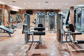 A gym with a variety of equipment including weights and machines.