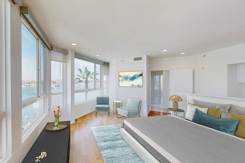 A bedroom with a large bed and a view of the ocean.