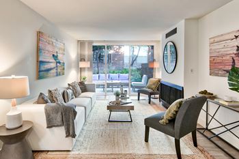 A living room with a white couch, a coffee table, and a large painting on the wall.