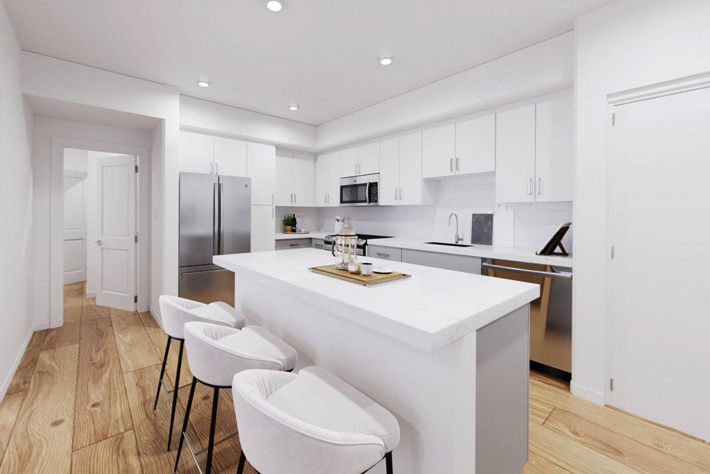 A modern kitchen with white countertops and bar stools at The Villas at Anacapa Canyon, Camarillo, 93012