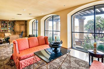 A living room with a red sofa and a glass coffee table.