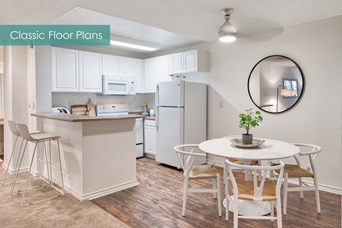 A kitchen with a white table and chairs.