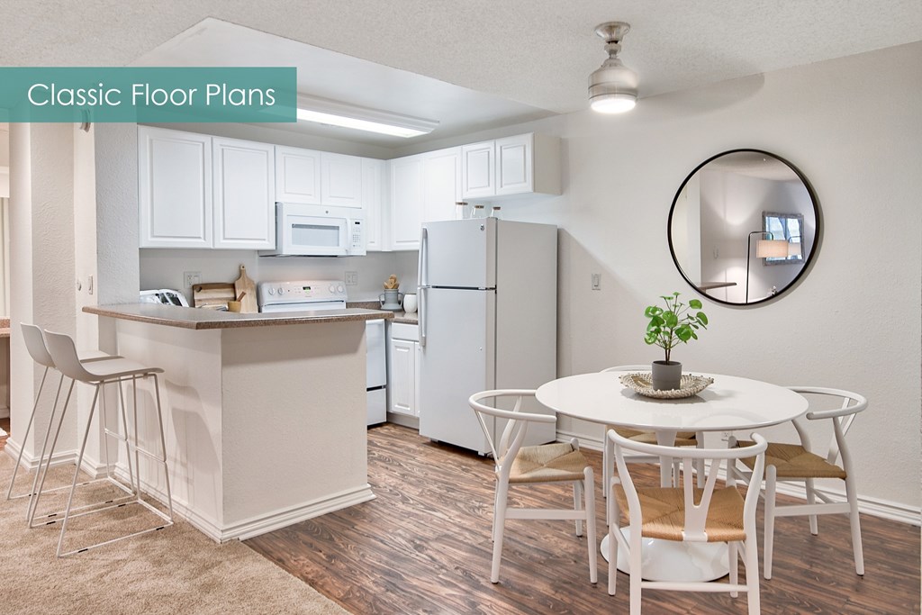 A kitchen with a white table and chairs.