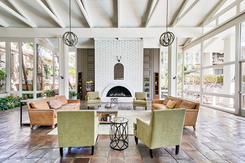 A living room with a fireplace and a white brick wall.