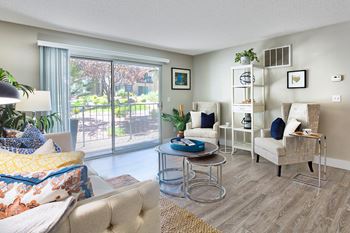 A living room with a sofa, chair, and a table with a plant on it.
