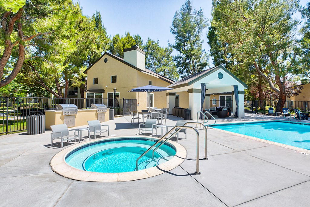 A pool with a hot tub and a house in the background at Mountain Vista, Victorville, CA