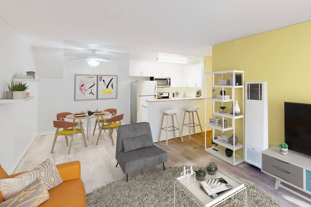 A living room with a grey sofa, a white coffee table, and a yellow accent wall at West Park Village, Los Angeles, CA