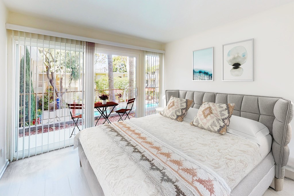 A bedroom with a large bed and a table outside at West Park Village, Los Angeles, CA
