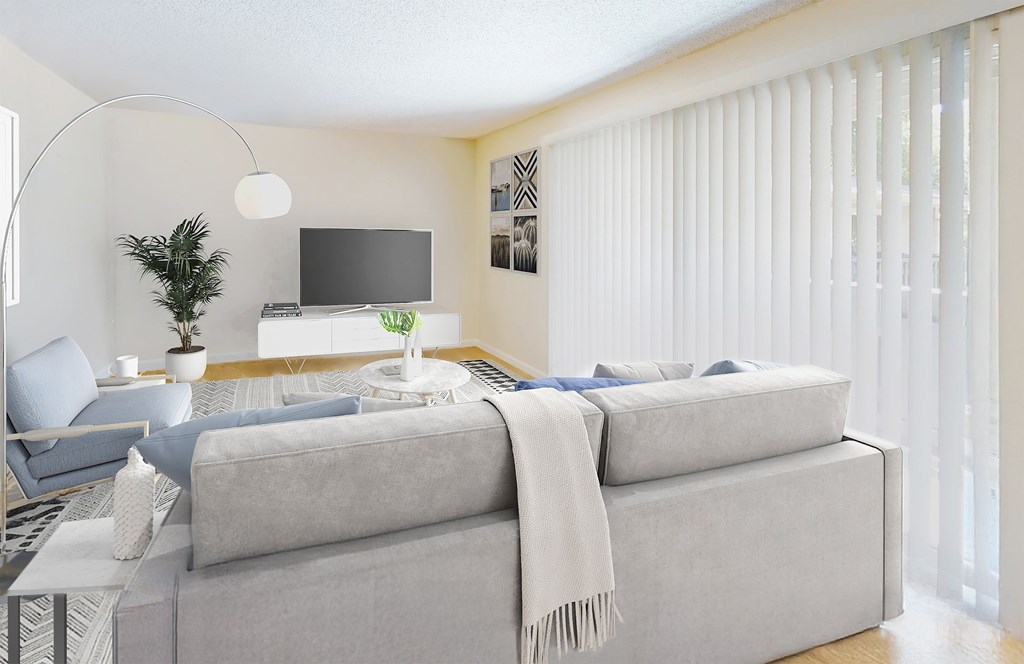 A modern living room with a grey sofa and a television.