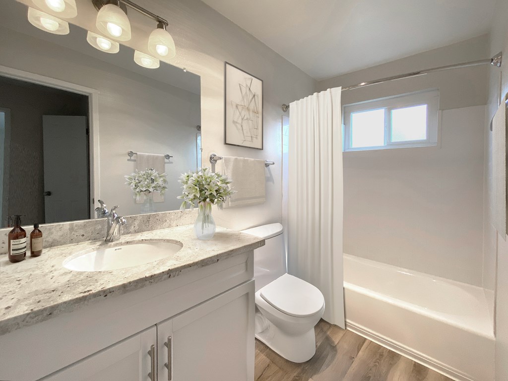 A white bathroom with a toilet, sink, and shower at Pleasanton Heights, California