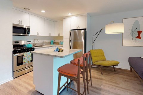 A kitchen with a blue island and a yellow chair.