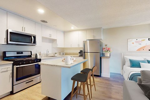 A kitchen with white cabinets and a blue island.
